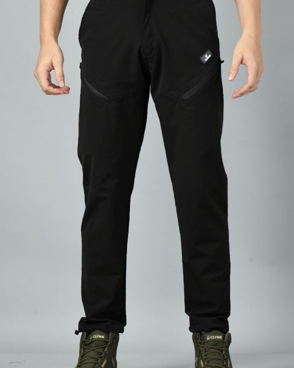A pair of black nylon spandex trekking pants with reinforced stitching and zipped pockets, paired with hiking boots.