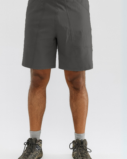 Person wearing gray shorts and hiking boots on a white background