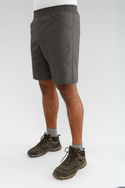 Person wearing dark grey shorts and hiking boots on a white background