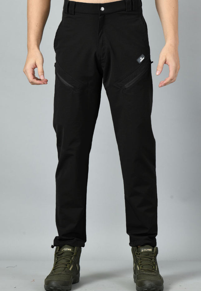 A pair of black nylon spandex trekking pants with reinforced stitching and zipped pockets, paired with hiking boots.