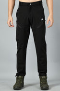 A pair of black nylon spandex trekking pants with reinforced stitching and zipped pockets, paired with hiking boots.