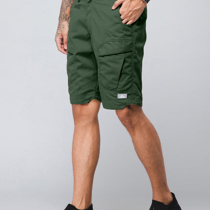 Person wearing Olive casual hiking cargo shorts on a gray background